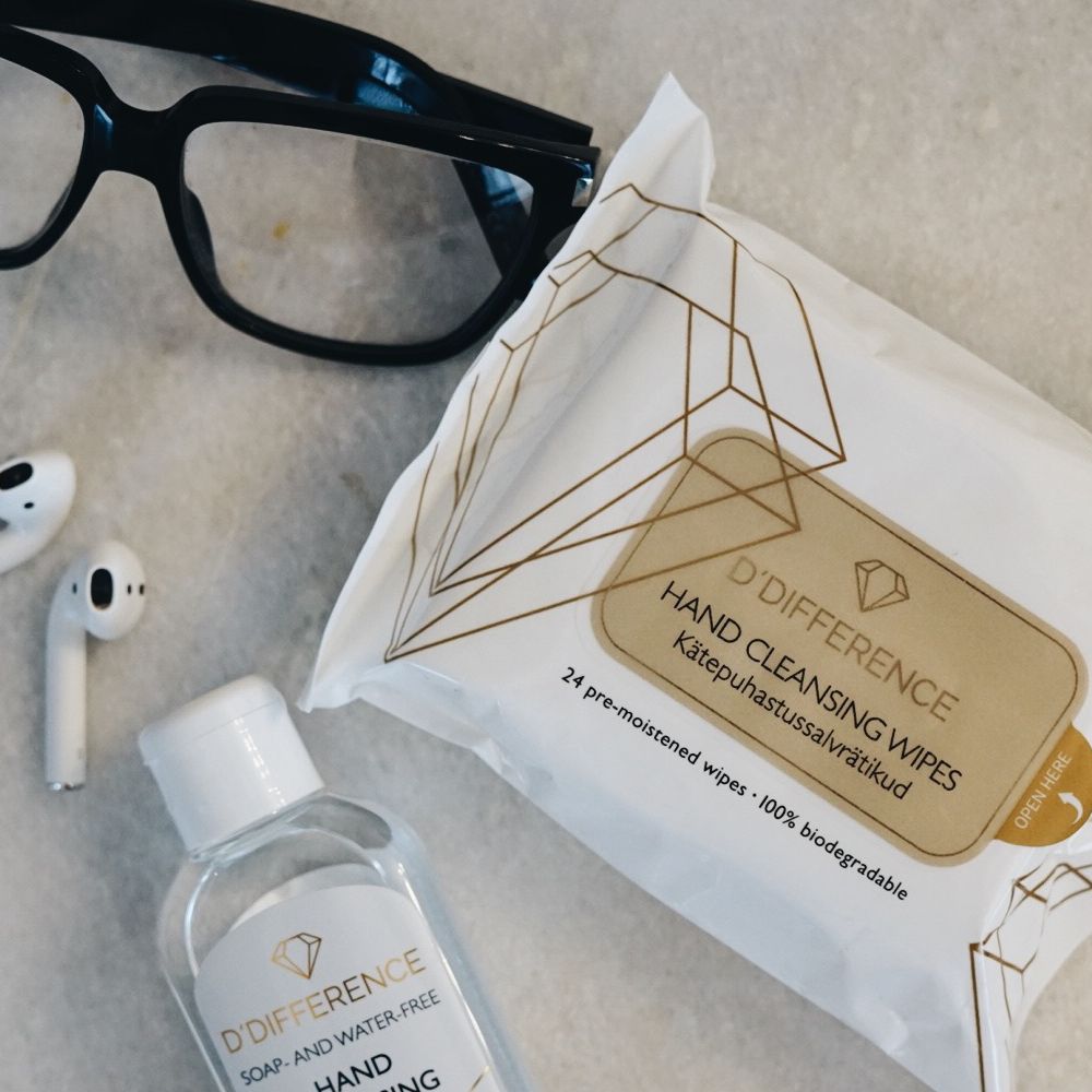 D'DIFFERENCE pouch of hand cleansing wipes on a mood background with glasses, earphones and cleansing gel.