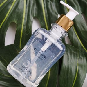 A 300 ml bottle of D'DIFFERENCE essential natural beauty Intimage Gel with a golden pump on a natural background of a palm leaf