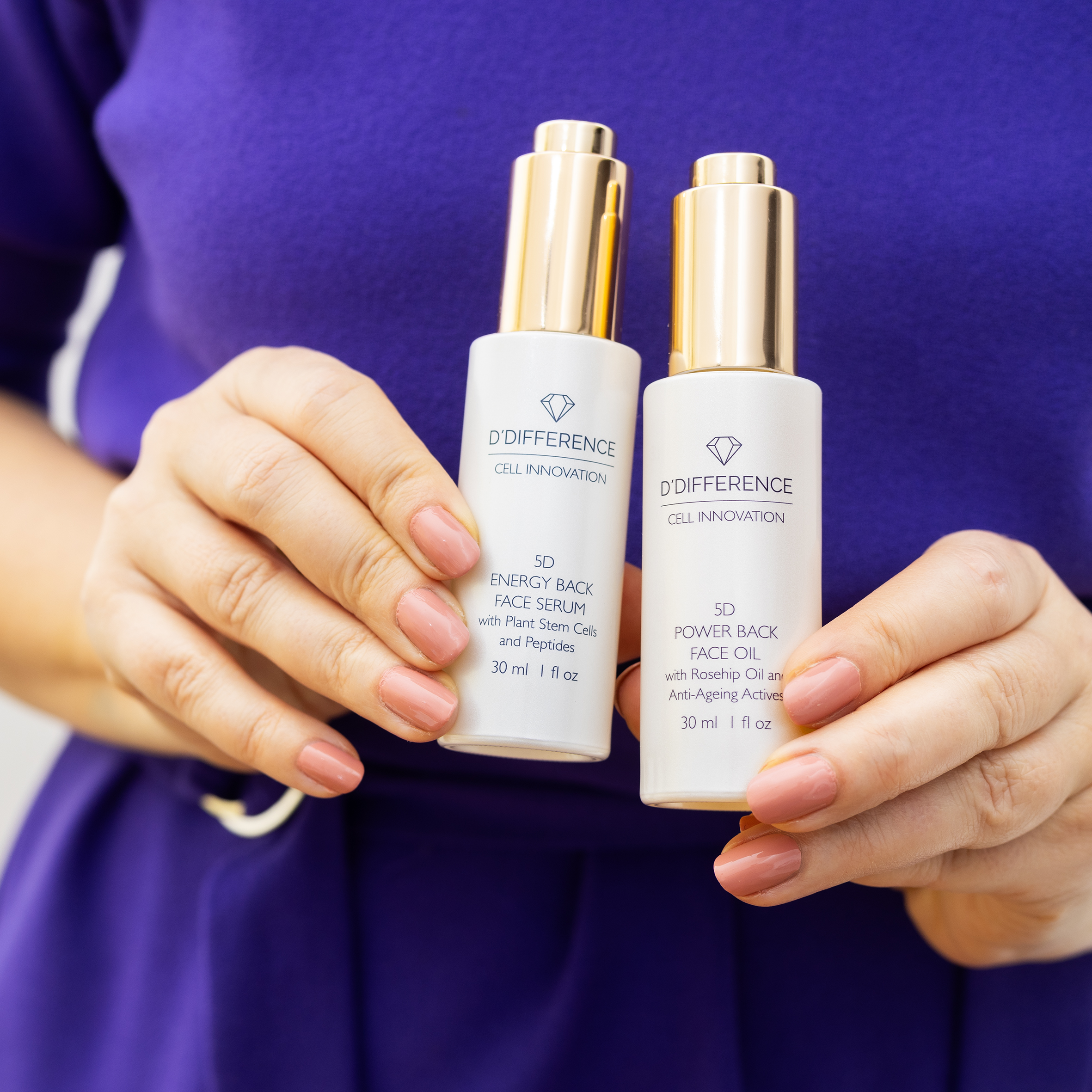 Woman holding D'DIFFERENCE Power Back Face Oil and Energy Back Face Serum in hand.