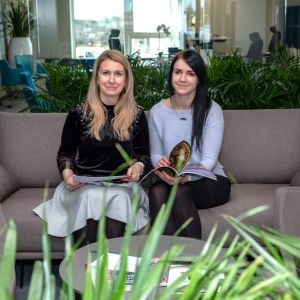Kätlin & Kaisa in D'DIFFERENCE office in Tallinn, Estonia sitting on a couch holding a magazine